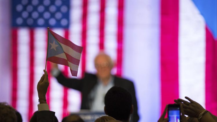 SAN JUAN, PUERTO RICO  MAY 16: A supporter of US Senator Bernie Sanders waves a flag during a campaign rally at Luis Muñoz Marín Foundation in Trujillo Alto, San Juan, Puerto Rico on May 16, 2016. (Photo by David Gasser/LatinContent/Getty Images)
